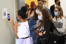 Masked students scanning a code with their phones