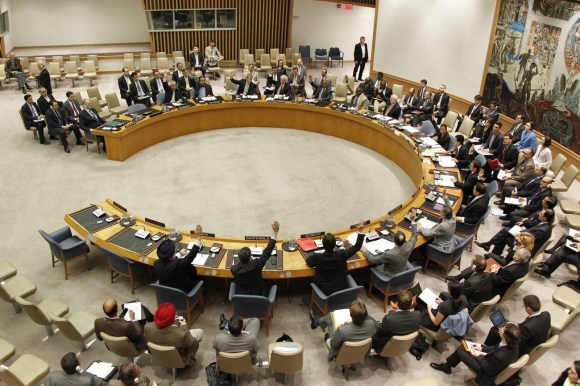 رجال ونساء جالسون داخل قاعة اجتماعات مجلس الأمن الدولي