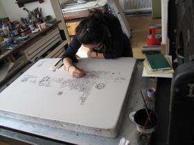the artist working on a print