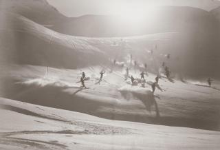 Vários esquiadores descendo um barranco