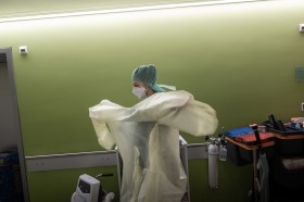 A doctor putting on a surgery gown at the hospital