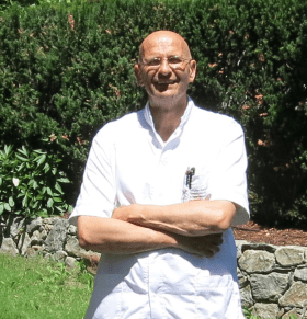 Un uomo che indossa un camice in piedi in un giardino