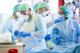 مجموعة من العاملين الصحيين يرتدون أقنعة داخل غرفة عمليات