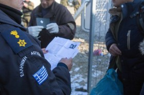 北マケドニアとの国境で難民をチェックするギリシャの警官