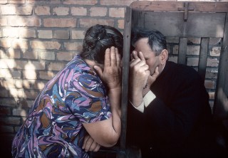 Priest and a woman at the confessional stool