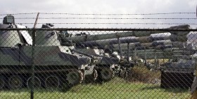 Tanks parked behind barbed wire