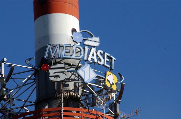 Dettaglio di torre metallica con vetta bianca e rossa e insegna Mediaset