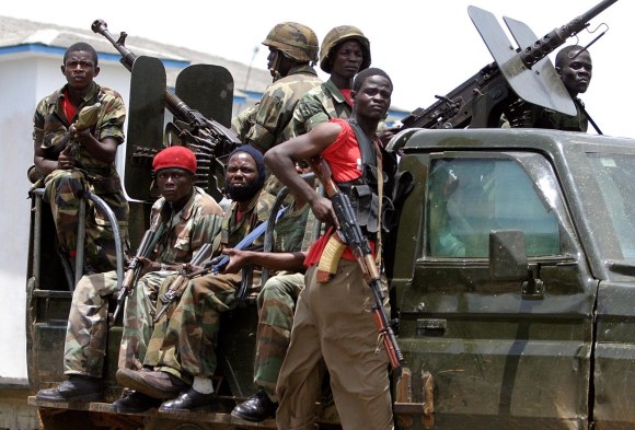 مجموعة من المقاتلين يحيطون بسيارة عسكرية أثناء الحرب الأهلية في ليبيريا