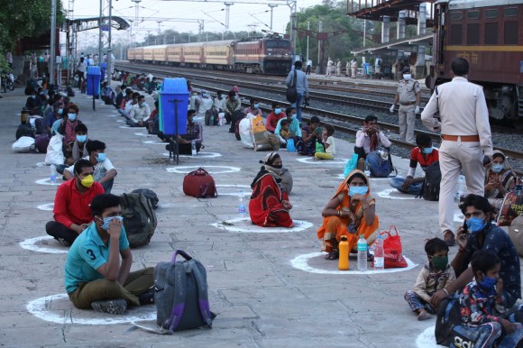 أشخاص ينتظرون إجلائهم في إحدى محطات القطار في الهند.
