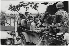 عسكريان يرافقان مجموعة من أسرى الحرب على متن يسيارة جيب