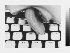 Língua de mulher lambe teclado de máquina de escrever