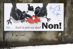 cartellone di propaganda dell UDC contro la libera circolazione, su cui sono raffigurati dei corvi che mangiano la Svizzera.