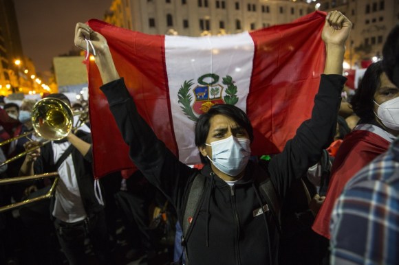 Manifestante con mascarilla y la bandera peruana