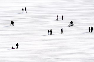 人们在冰封的黑湖上溜冰与散步