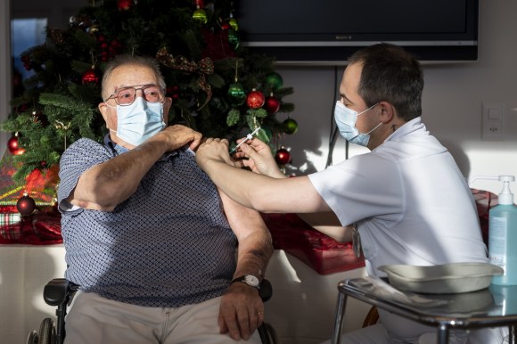 ممرض يقوم بتطعيم رجل مسن