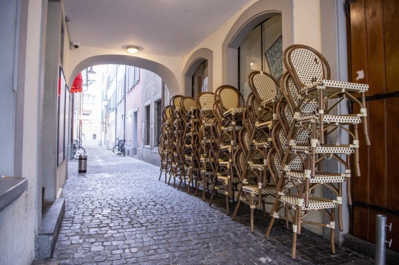 stacked up wicker chairs in an alley