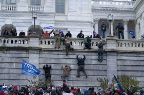 Gente escalando las paredes de la fachada del capitolio