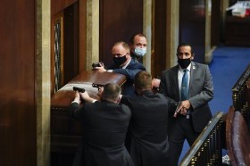抗議者が米連邦議会議事堂に侵入しようとした時。ドアの後ろで銃を構える警察たち