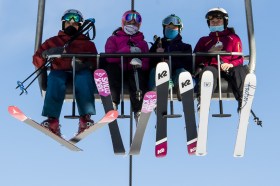 masked people on ski lift