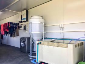 Waschmaschine und Wäsche im Container
