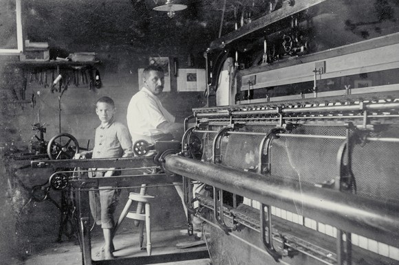 Criança trabalhando ao lado de um operário em uma fábrica
