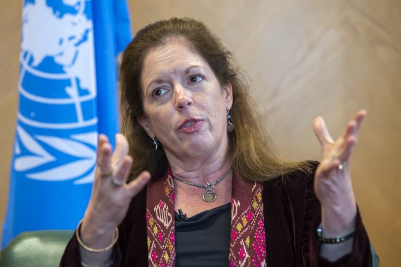 امرأة تتحدث وفي الخلف علم الأمم المتحدة