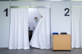 Doctor pulling back a curtain