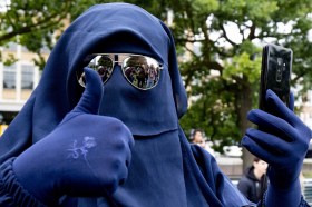 woman wearing blue burka and sunglasses