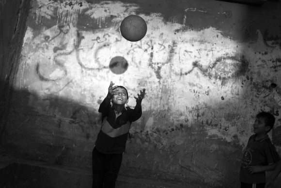صورة بالأبيض والأسود لطفل يلعب بكرة