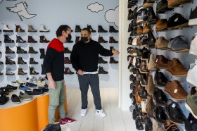 رجلان يرتديان كمامات داخل متجر لبيع الأحذية