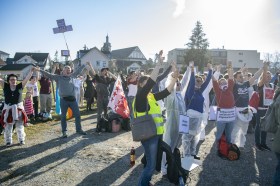 Gruppe von Demonstranten hält Hände und zeigt Transparente