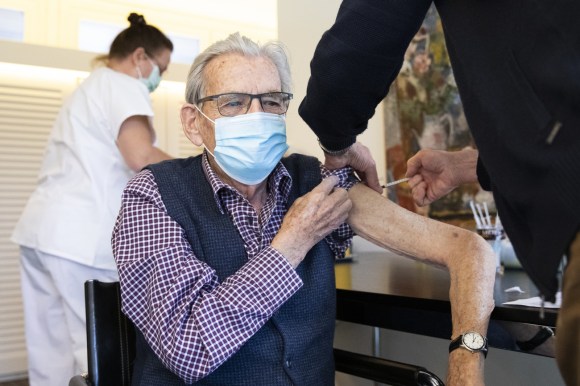 Una enfermera vacuna a un señor mayor