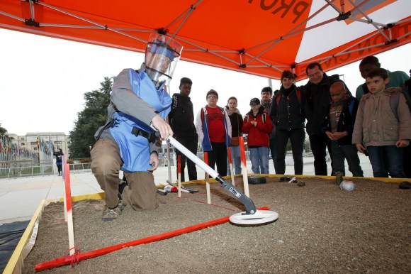 A demining expert shows a metal detector searching for land mines