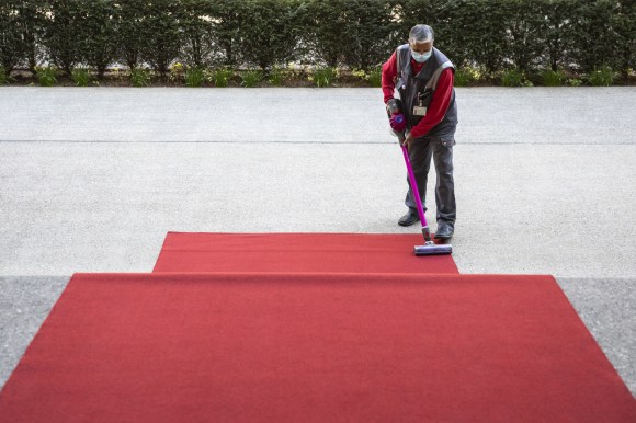 赤いカーペットを掃除する男性