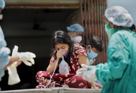 Workers attend a suspected Covid patient in India
