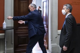 Dois ministros suíços limpando as mãos com álcool gel