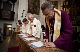 Bischöfe unterzeichnen ein Dokument.