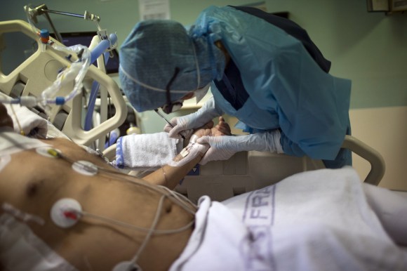 法国医院重症监护室：一名护士在新冠重症病人的手上标注信息。