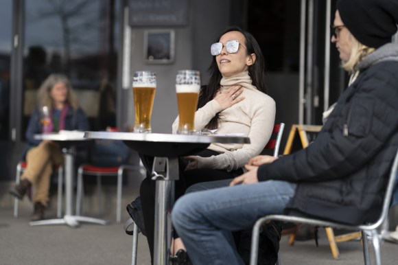 Una mujer consume en la terraza de un bar en Zúrich
