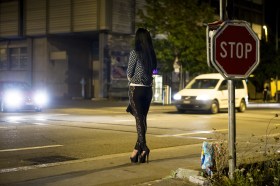فتاة مشتغلة بالدعارة تقف على حافة رصيف في الشارع