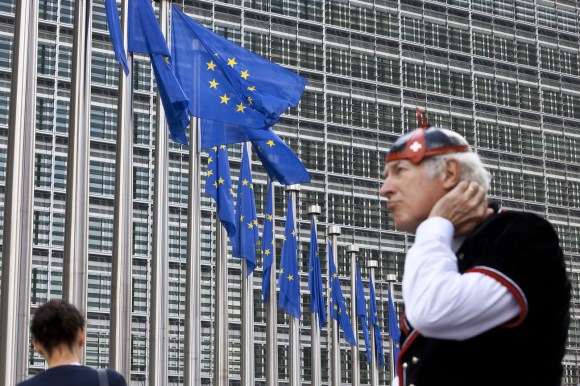 Man in traditional Swiss costume outside EU building