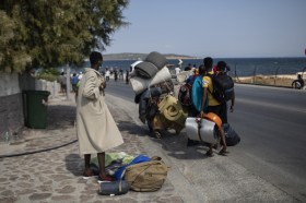 Refugees on a road near a coast in Greece