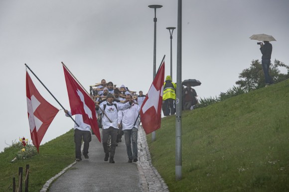 Group of protesters with in traditional white shirts and Swiss flags