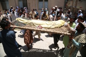 People move the body of a polio vaccination worker who was killed in Jalalabad.