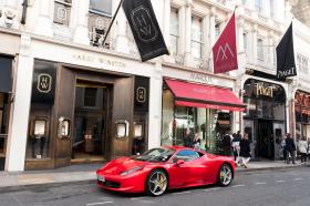 Ferrari parked outside of designer shops.