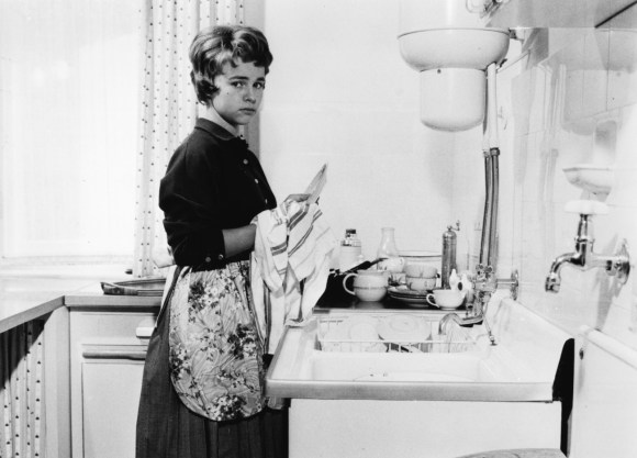 امراة في المطبخ تغسل الأطباق
