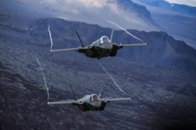 F-35A aircraft flying over mountains