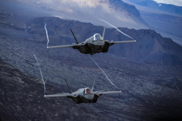 F-35A aircraft flying over mountains