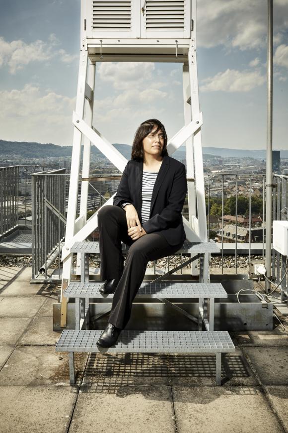 امرأة تجلس فوق مدرج على سطح مبنى