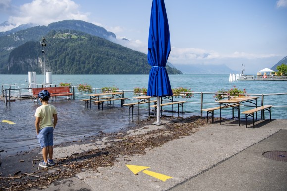 Boy standing on a flooded pier on Lake Lucerne